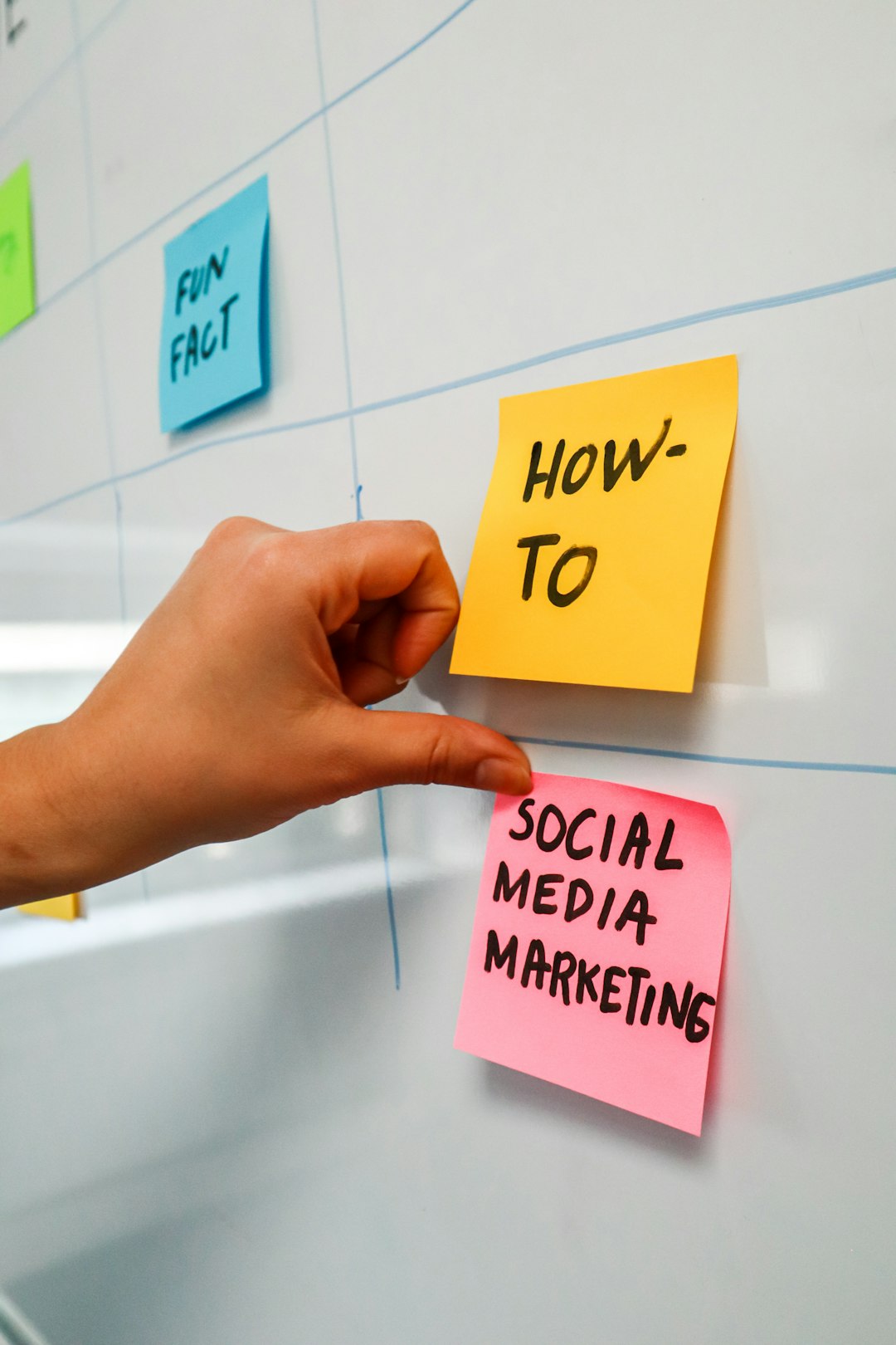 project-01-b Person sticking a post-it on a white board with the words "Social Media Marketing" written on it